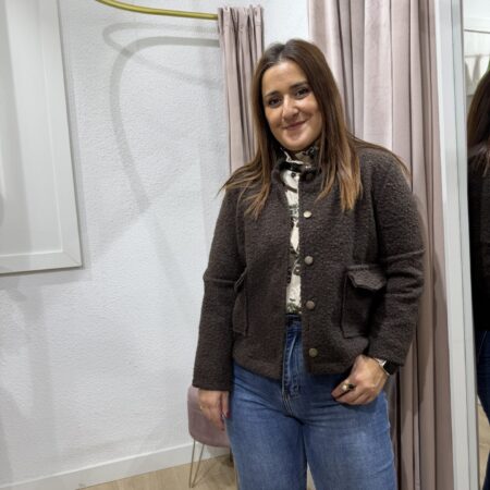 Chaqueta lanosa de estilo Chanel en tono verde chocolate marrón con bolsillos frontales y textura bouclé combinada con pantalón vaquero.